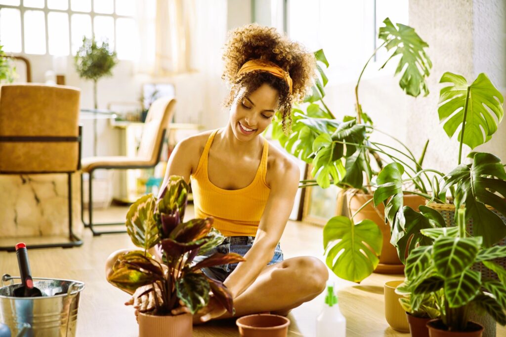 woman with curly hair planting in living room